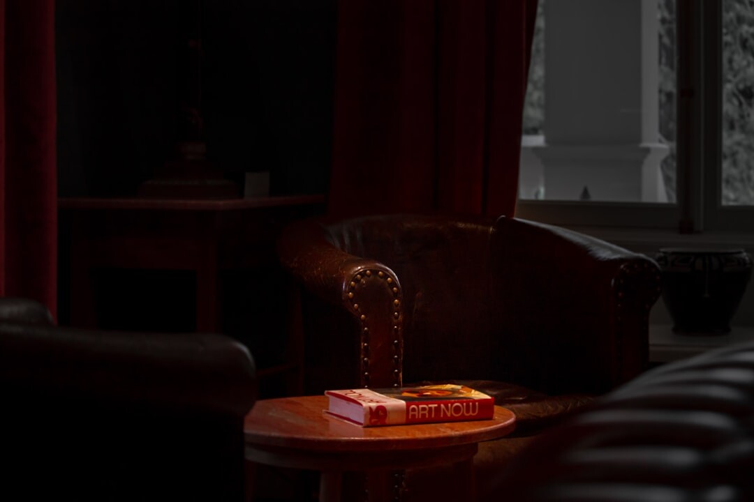 Quiet reading study with armchair and stacked crime novels